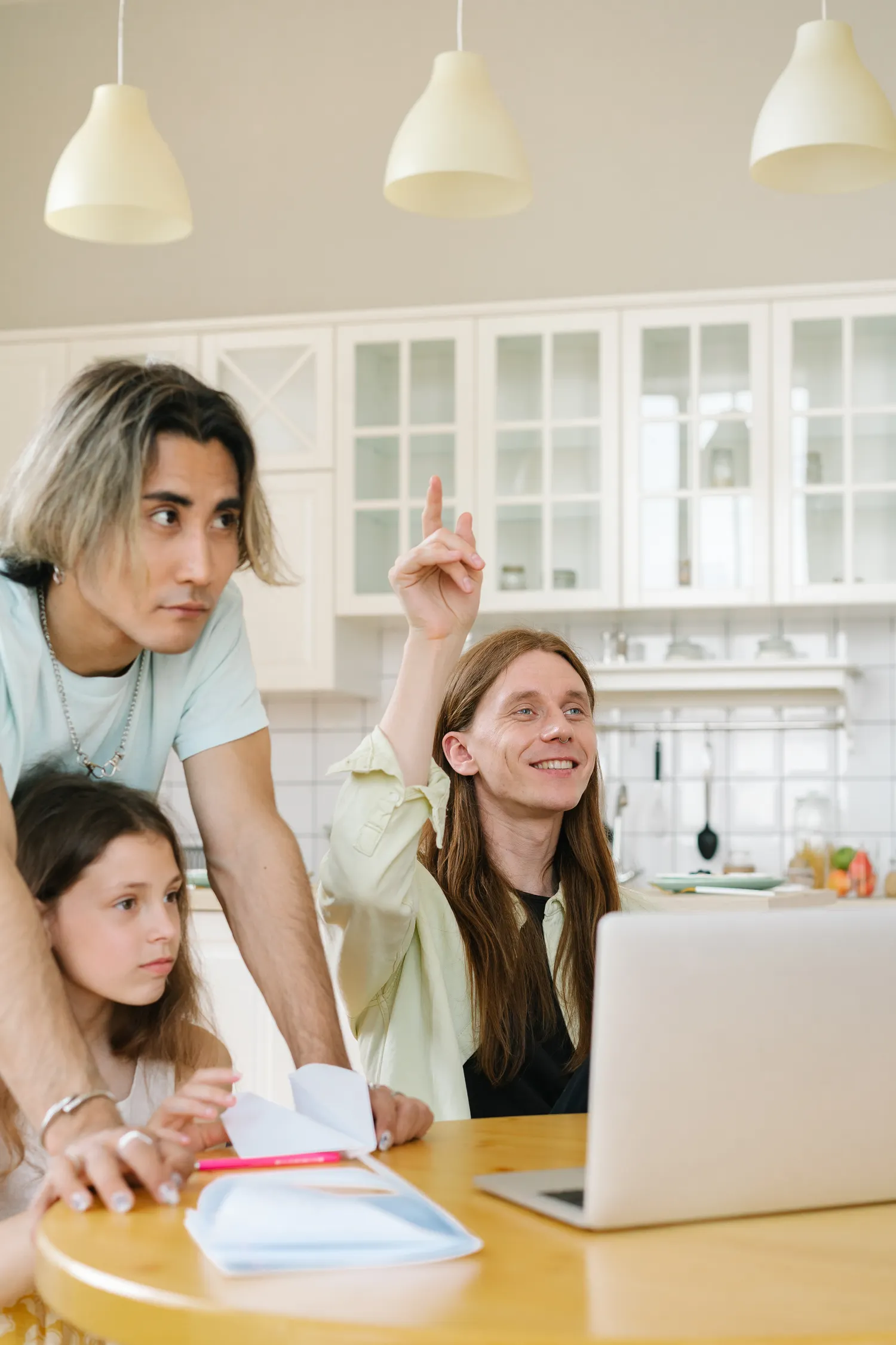 Family using a laptop together at a kitchen table