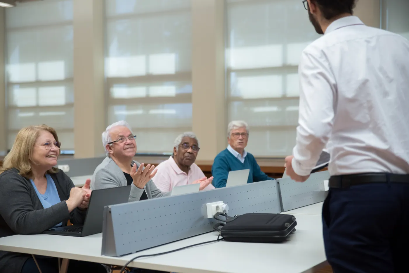Adults learning digital skills with laptops in a community class